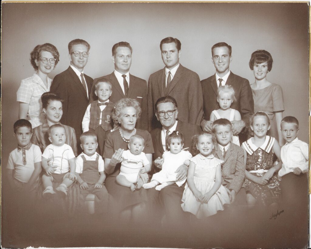 A large family portrait shows 20 members, including children and adults