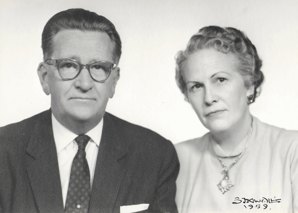 Black and white portrait of a couple from 1959, the man in a suit and glasses